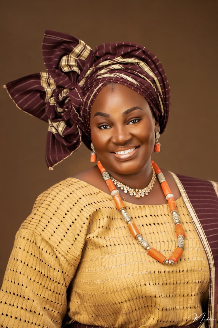 Gold and wine aso-oke bridal portrait with coral beads